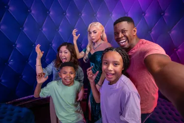 Family of four poses for a selfie with the Lady Gaga wax figure at Madame Tussauds Orlando.
