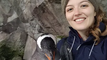 Jess smiling with her penguin friend