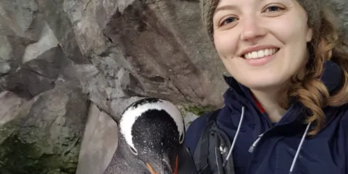 Jess smiling with her penguin friend