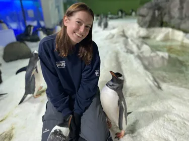 Kiara smiling with her penguin friends