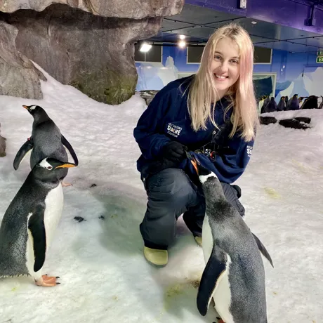 Katie smiling with her penguin friends