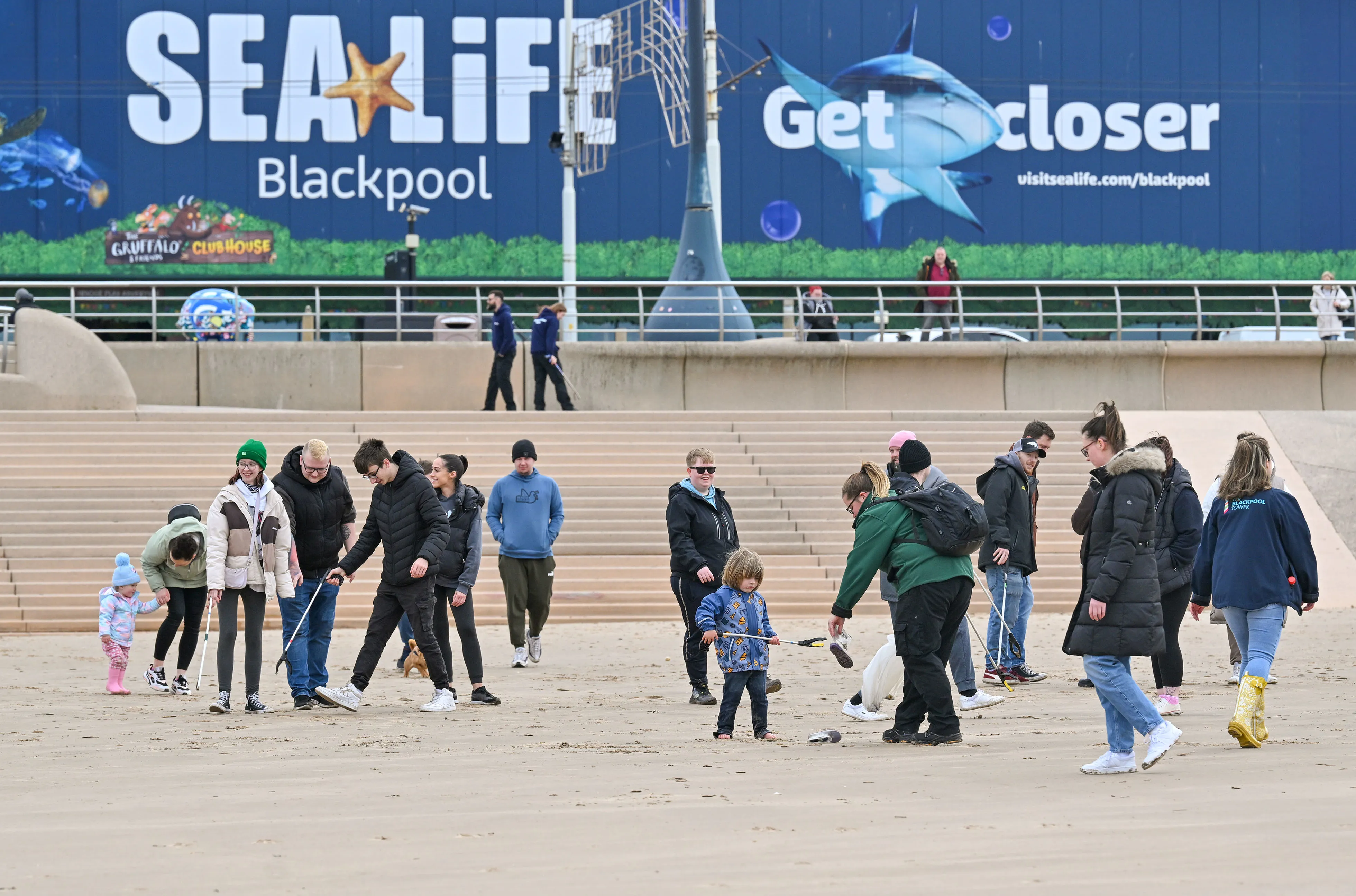 A groups of people litter picking on Blackpool Beach in front of SEA LIFE Blackpool