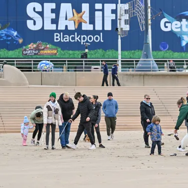 A groups of people litter picking on Blackpool Beach in front of SEA LIFE Blackpool