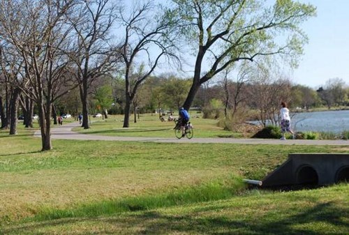 People walking and riding on the 9 miles trail around White Rock Lake.