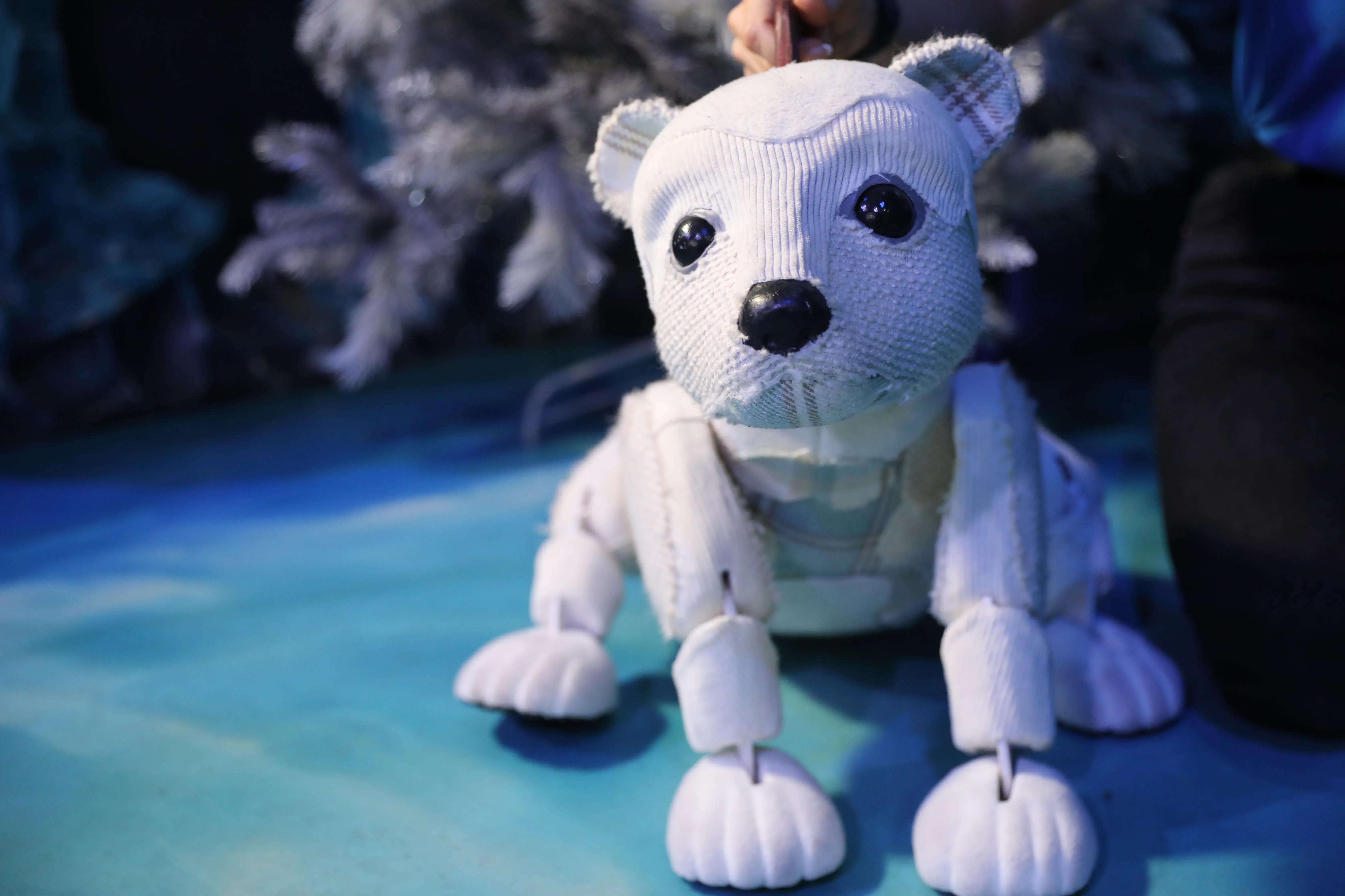 Al the Polar Bear posing on the floor infront of a christmas tree