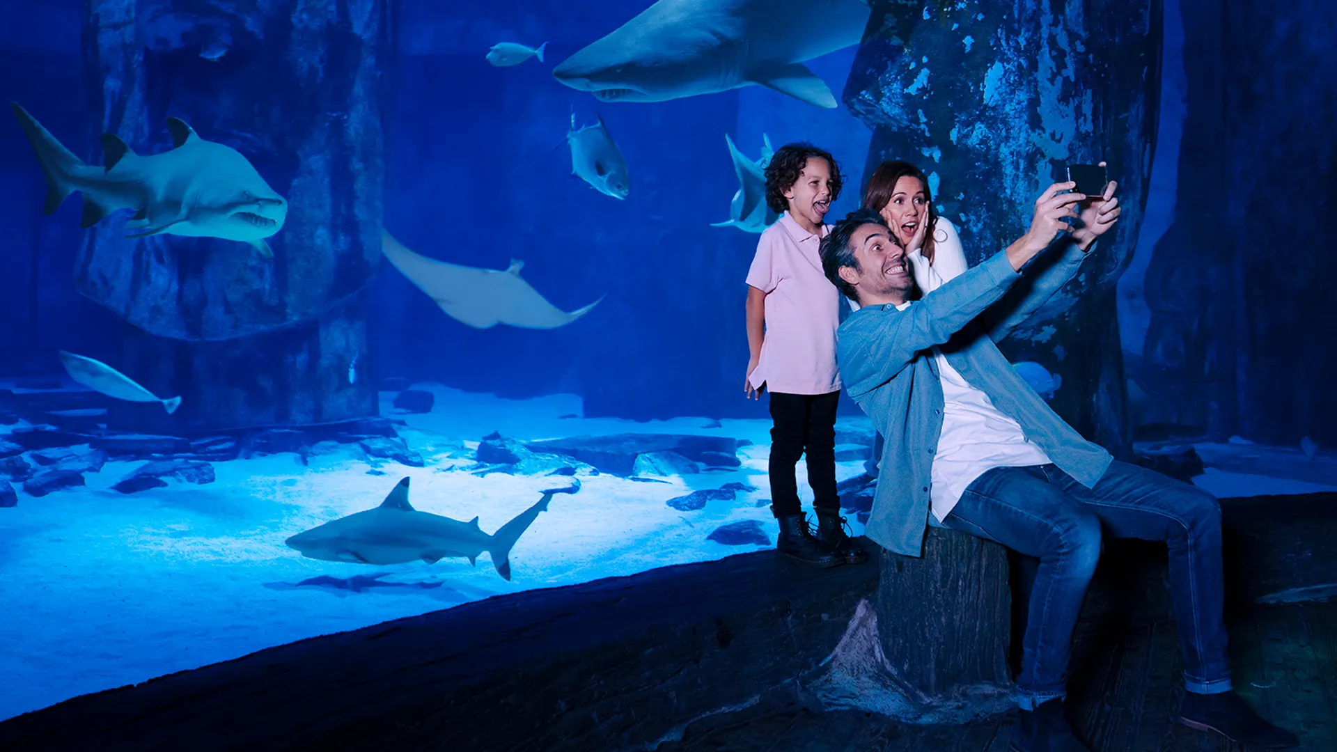 Family selfie with sharks and rays at SEA LIFE New Jersey.
