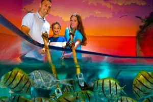Father and son learning how to feed the fish nori with a SEA LIFE Orlando employee