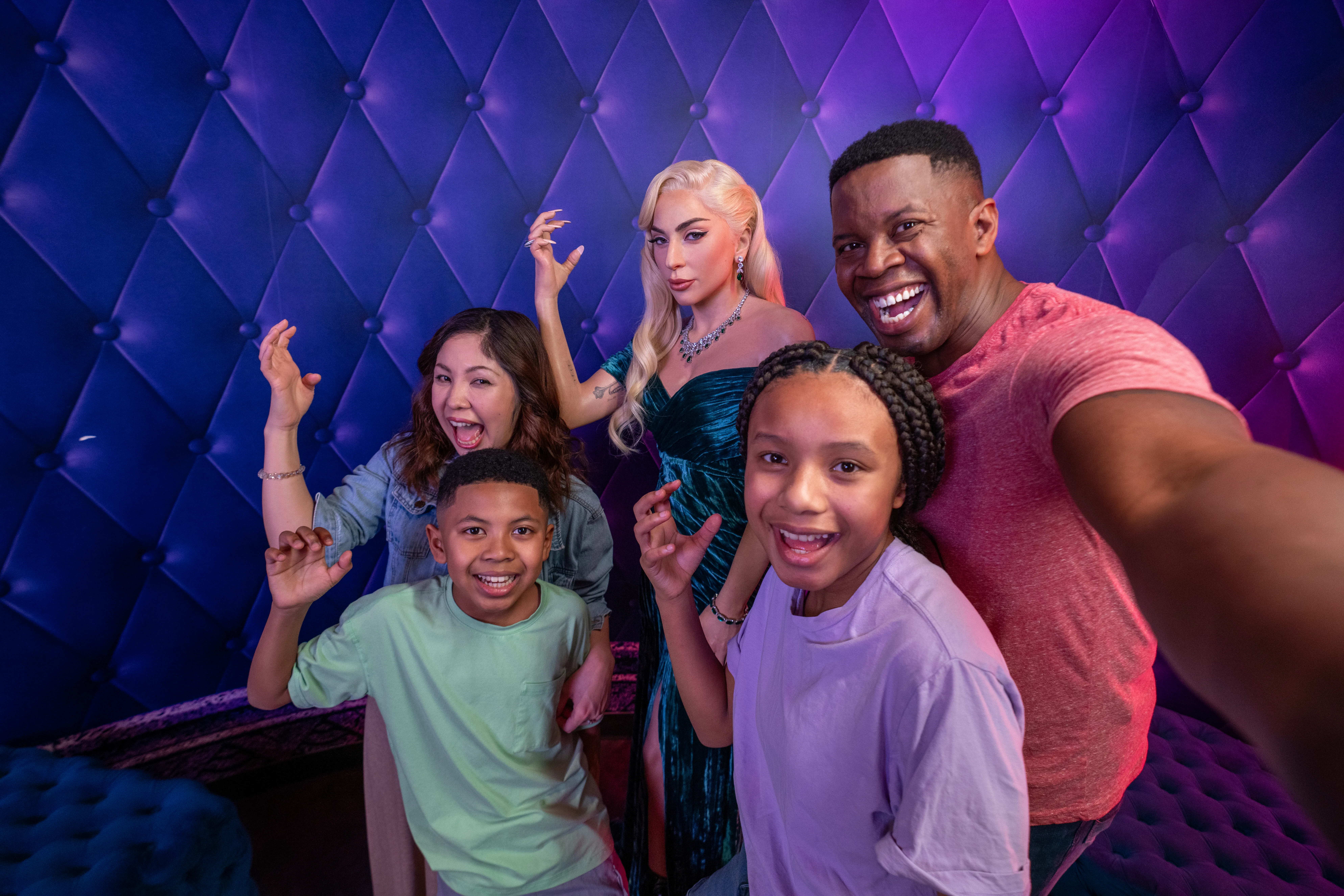 Family of four poses for a selfie with the Lady Gaga wax figure at Madame Tussauds Orlando.