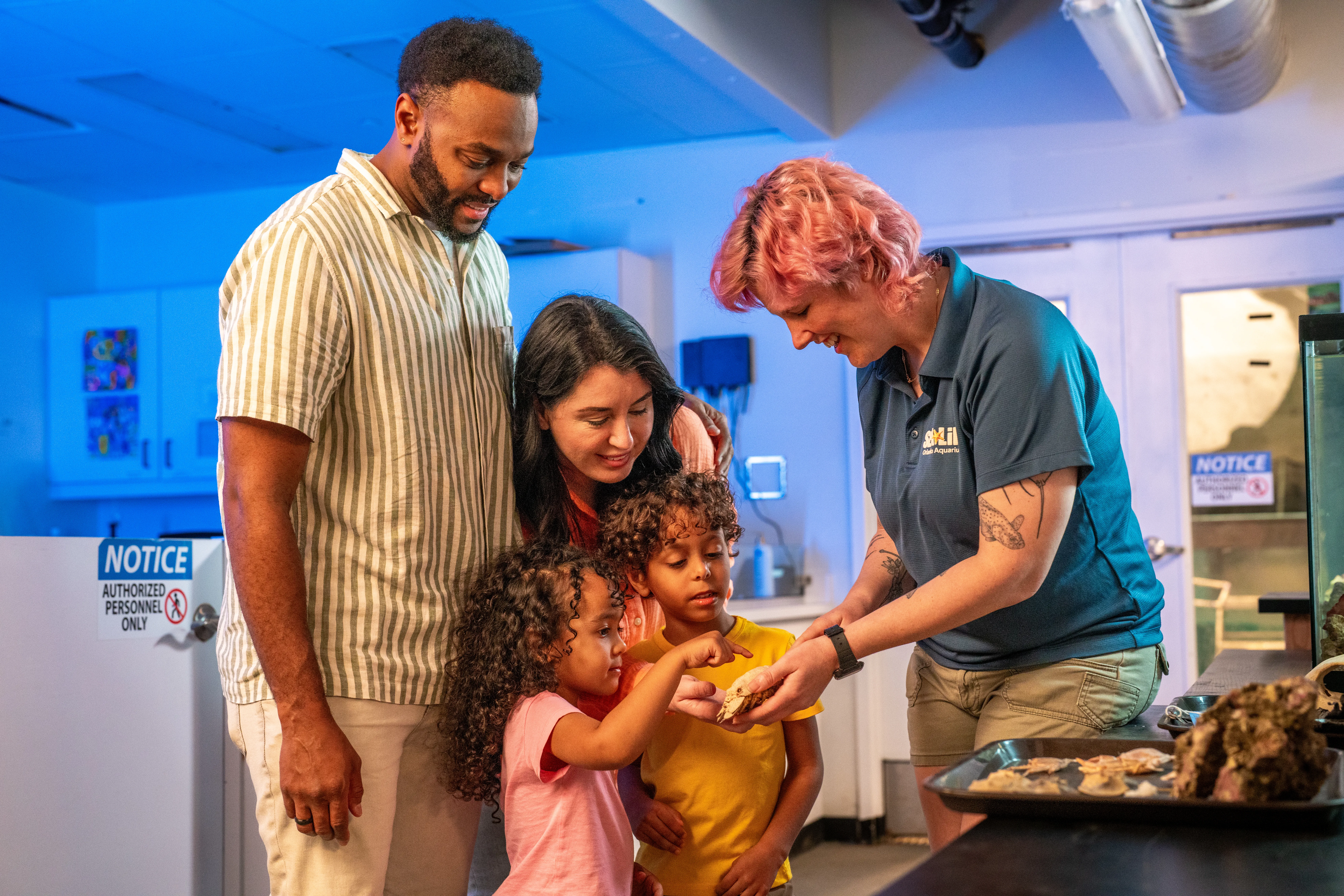 Family experience the Behind the Scenes Tour with the children interacting with an exhibit