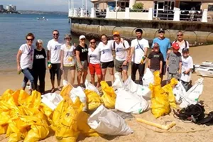 Group of people cleaning the beach with recycled bags