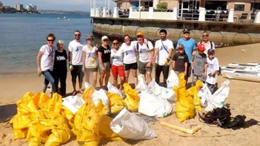 Group of people cleaning the beach with recycled bags
