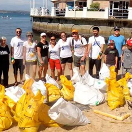 Group of people cleaning the beach with recycled bags