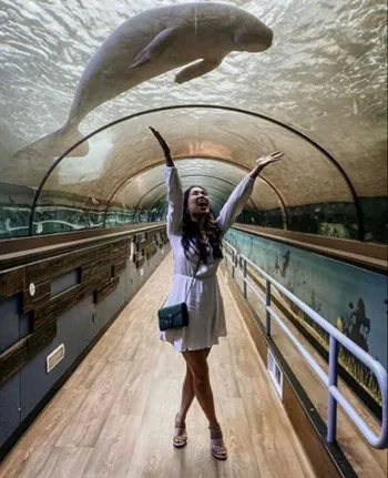 A guest posing in the Dugong tunnel at SEA LIFE - a great Instagrammable place in Sydney